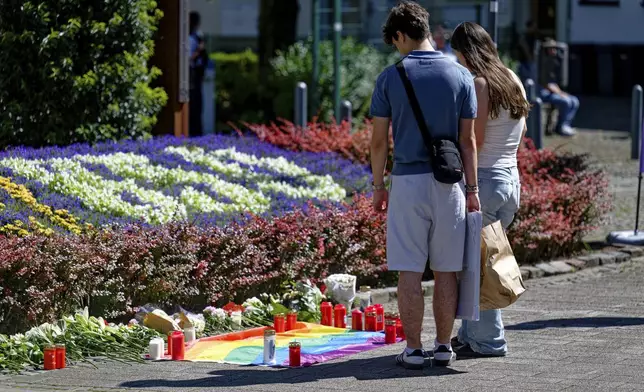 People lay flowers near the scene of a knife attack in Solingen city center, Germany, Saturday Aug. 24, 2024, after three people were killed and at least eight people were wounded Friday night at the festival. (Henning Kaiser/dpa via AP)