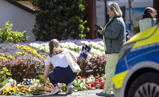 Flowers and candles are placed in Solingen, Germany, Sunday, Aug. 25, 2024, near the scene of Friday's deadly attack. (Thomas Banneyer/dpa via AP)