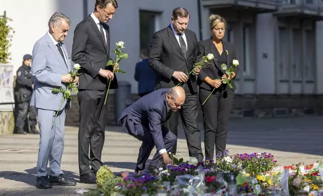 From left, Herbert Reul, Minister of the Interior of North Rhine-Westphalia, Hendrik Wüst, Minister President of North Rhine-Westphalia, German Chancellor Olaf Scholz, Tim Kurzbach, Mayor of Solingen, and Mona Neubaur, Deputy Minister President of North Rhine-Westphalia lay flowers, near the scene of a knife attack, in Solingen, Germany, Monday, Aug. 26, 2024. (Thomas Banneyer/dpa via AP)