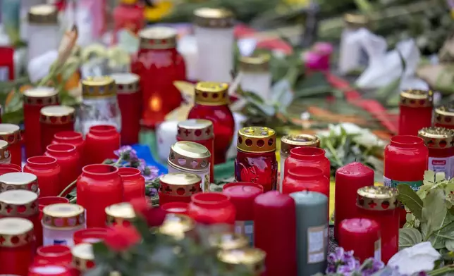 Flowers and candles are placed Sunday, Aug. 25, 2024, near the scene of Friday's deadly attack at the city's 650th anniversary celebrations in the city center of Solingen, Germany. (Thomas Banneyer/dpa via AP)