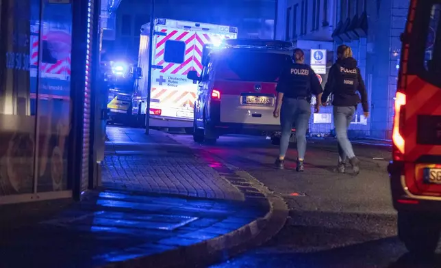 Police forces are deployed near the scene where people were killed and injured in an attack at a festival in Solingen, western Germany, the German dpa news agency reported, Friday, Aug. 23, 2024. (Gianni Gattus/dpa via AP)