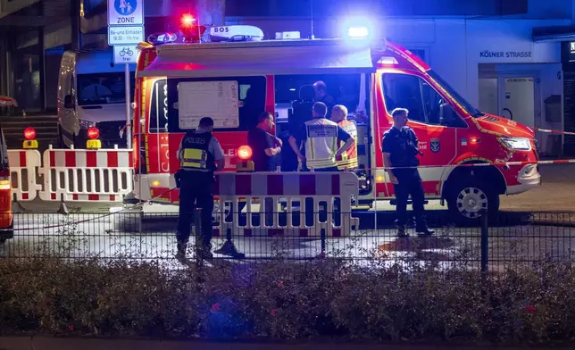 Emergency services and police are deployed near the scene where people were killed and injured in an attack at a festival in Solingen, western Germany, the German dpa news agency reported, Friday, Aug. 23, 2024. (Gianni Gattus/dpa via AP)