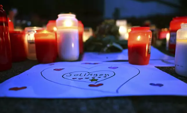 Candles sit at a memorial at the city center in Solingen, Germany, Tuesday, Aug. 27, 2024, after a deadly knife attack during a festival on Friday, Aug. 23. (Federico Gambarini/dpa via AP)