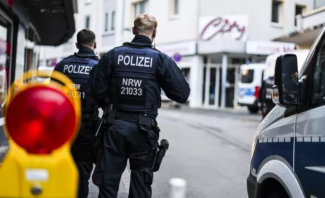 Police officers stand at a cordon in the city center in the early morning in Solingen, Germany, Saturday, Aug. 24, 2024, following Friday's deadly attack at the city's 650th anniversary celebrations. (Christoph Reichwein/dpa via AP)