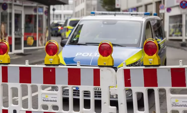 Police emergency vehicles stand at a cordon in the city center of Solingen, Germany, in the early morning of Sunday, Aug. 25, 2024, following Friday's deadly attack at the city's 650th anniversary celebrations. (Thomas Banneyer/dpa via AP)