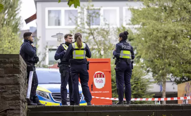 Emergency vehicles and police officers stand at a cordon in the city center of Solingen, Germany, Sunday, Aug. 25, 2024, near the scene of Friday's deadly attack. (Thomas Banneyer/dpa via AP)