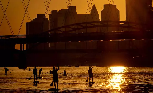 People paddle over the river Main in Frankfurt, Germany, as the sun sets on Monday, Aug. 26, 2024. (AP Photo/Michael Probst)