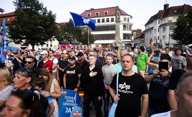 Supporters of the far-right Alternative for Germany party, or AfD, sing the national anthem as they attend an election campaign rally of the party for upcoming state elections in Suhl, Germany, Tuesday, Aug. 13, 2024. In the federal state Thuringia, in former East Germany, the citizens are called to vote for a new state parliament on Sept. 1, 2024. (AP Photo/Markus Schreiber)