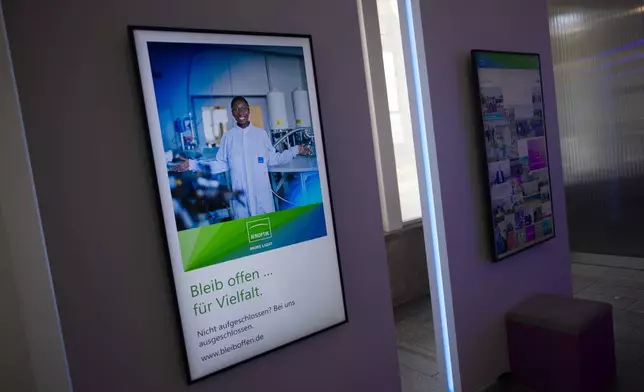 A poster of the Jenotik company to promote its foreign employees with portraits displayed at its Jena headquarters with the slogan "Stay Open for Diversity." in Jena, Germany, Monday, Aug. 12, 2024. The company wants to use the campaign to attract foreign skilled workers. (AP Photo/Markus Schreiber)