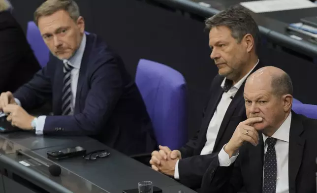 FILE - From right, German Chancellor Olaf Scholz, Economy and Climate Minister Robert Habeck and Finance Minister Christian Lindner listen to a debate about Germany's budget crisis at the parliament Bundestag in Berlin, Germany, Nov. 28, 2023. (AP Photo/Markus Schreiber, File)