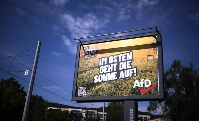 An electoral poster for the far-right Alternative for Germany, or AfD, using the slogan "The Sun Rises in the East", is displayed in a street in the federal state Thuringia city Jena, Germany, Wednesday, Aug. 14, 2024. In the federal state Thuringia, in former East Germany, the citizens are called to vote for a new state parliament on Sept. 1, 2024. (AP Photo/Markus Schreiber)