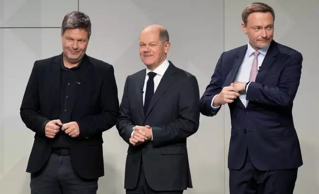 FILE - Green party co-leader and designated Economy and Climate Minister Robert Habeck, designated Chancellor Olaf Scholz and FDP party leader and designated Finance Minister Christian Lindner, from left, stand together after signing the coalition treaty in Berlin, Dec. 7, 2021. (AP Photo/Markus Schreiber, File)