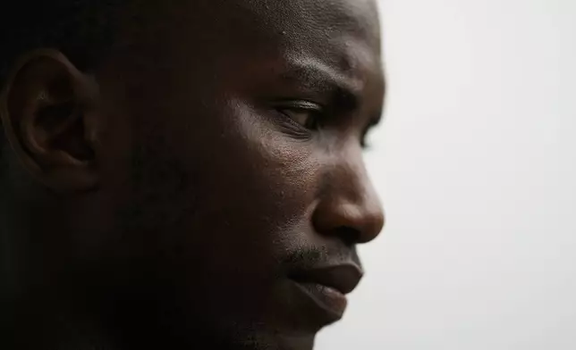 Omar Diallo, a 22-year-old migrant from Guinea in West Africa, poses for a portrait Wednesday, Aug. 14, 2024, during an interview with The Associated Press near a dilapidated storage building where he and two friends were hunted and beaten up in 2020, in Erfurt, Germany. (AP Photo/Markus Schreiber)