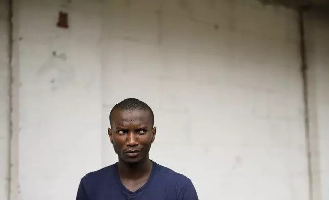 Omar Diallo, a 22-year-old migrant from Guinea in West Africa, poses for a portrait Wednesday, Aug. 14, 2024, during an interview with The Associated Press near a dilapidated storage building where he and two friends were hunted and beaten up in 2020, in Erfurt, Germany. (AP Photo/Markus Schreiber)