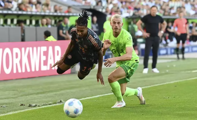 Bayern's Michael Olise, left, in action against Wolfsburg's Jakub Kaminski during the German Bundesliga soccer match between VfL Wolfsburg and FC Bayern Munich at the Volkswagen Arena in Wolfsburg, Germany, Sunday, Aug. 27, 2024. (Swen Pfoertner/dpa via AP)