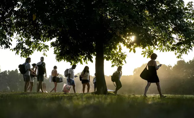 People cool off at the edge of a lake on a hot summer day in Berlin, Germany, Thursday, Aug. 29, 2024. (AP Photo/Ebrahim Noroozi)