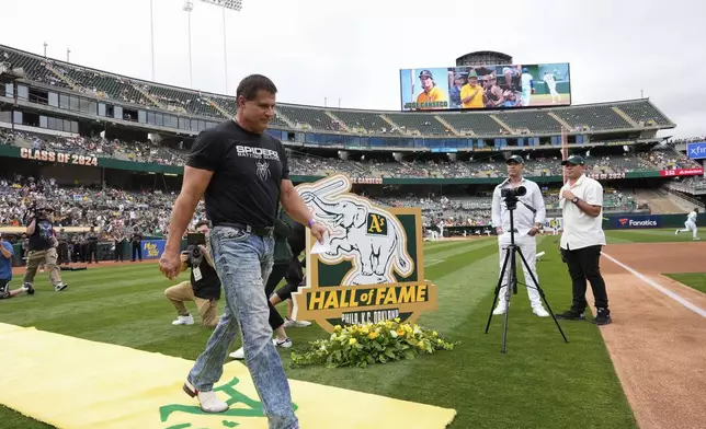 Former Oakland Athletics player Jose Canseco, foreground, is introduced during the team's Hall of Fame ceremony before a baseball game against the San Francisco Giants, Saturday, Aug. 17, 2024, in Oakland, Calif. (AP Photo/Godofredo A. Vásquez)