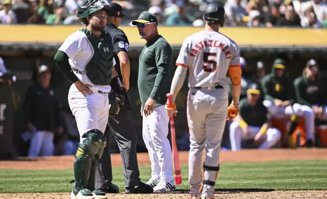 Oakland Athletics manager Mark Kotsay, center, argues with home plate umpire Emil Jimenez (82) during the eighth inning of a baseball game against the San Francisco Giants, Sunday, Aug. 18, 2024, in Oakland, Calif. (AP Photo/Eakin Howard)