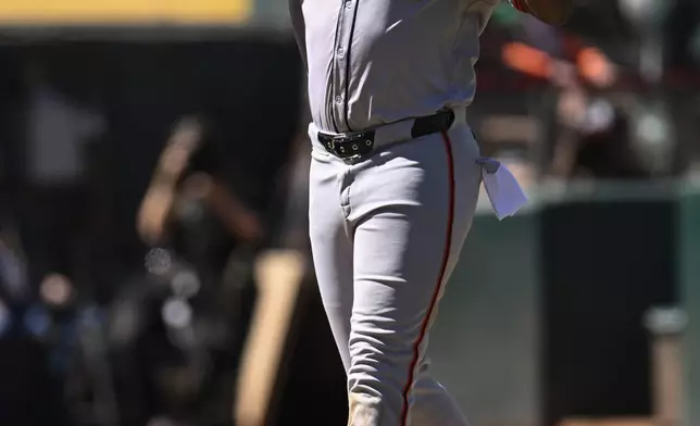 San Francisco Giants' Jerar Encarnacion celebrates after his two-run home run as he runs home against the Oakland Athletics during the tenth inning of a baseball game Sunday, Aug. 18, 2024, in Oakland, Calif. (AP Photo/Eakin Howard)