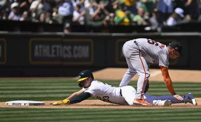 San Francisco Giants third baseman Matt Chapman, top, tags out Oakland Athletics' JJ Bleday, bottom, who slides into third during the sixth inning of a baseball game Sunday, Aug. 18, 2024, in Oakland, Calif. (AP Photo/Eakin Howard)