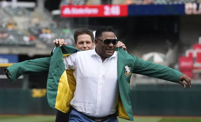 Former Oakland Athletics player Miguel Tejada, right, is inducted into the team's Hall of Fame before a baseball game against the San Francisco Giants, Saturday, Aug. 17, 2024, in Oakland, Calif. (AP Photo/Godofredo A. Vásquez)