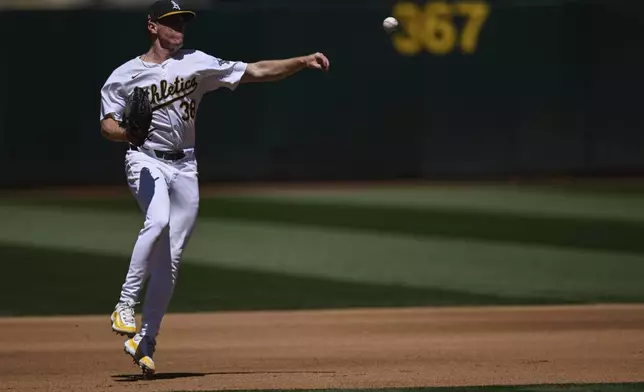 Oakland Athletics pitcher JP Sears throws to first base for an out against the San Francisco Giants during the fourth inning of a baseball game Sunday, Aug. 18, 2024, in Oakland, Calif. (AP Photo/Eakin Howard)