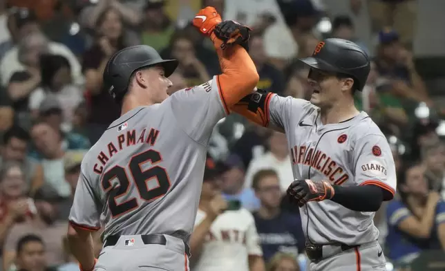 San Francisco Giants' Mike Yastrzemski is congratulated by Matt Chapman after hitting a two-run home run during the seventh inning of a baseball game against the Milwaukee Brewers Tuesday, Aug. 27, 2024, in Milwaukee. (AP Photo/Morry Gash)