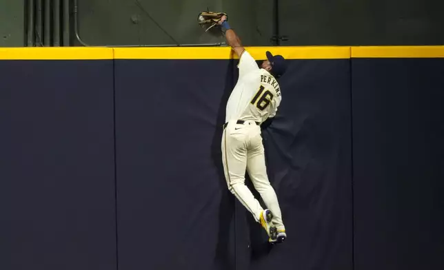 Milwaukee Brewers' Blake Perkins catches a ball over the wall hit by San Francisco Giants' Thairo Estrada during the fifth inning of a baseball game Tuesday, Aug. 27, 2024, in Milwaukee. (AP Photo/Morry Gash)