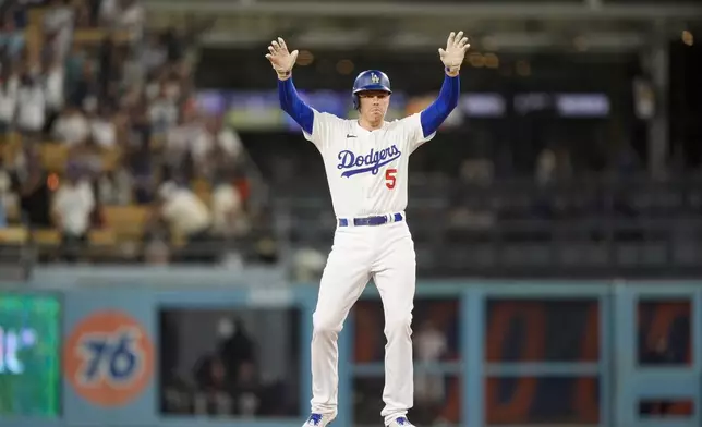 Los Angeles Dodgers' Freddie Freeman celebrates after hitting a double to score Nick Ahmed during the eighth inning of a baseball game against the San Francisco Giants, Wednesday, July 24, 2024, in Los Angeles. (AP Photo/Ryan Sun)