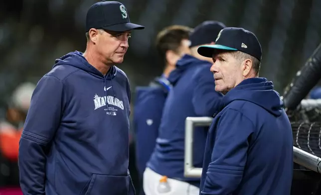 Seattle Mariners manager Dan Wilson, left, looks on next to hitting coach Edgar Martinez, right, during batting practice before a baseball game against the San Francisco Giants, Friday, Aug. 23, 2024, in Seattle. (AP Photo/Lindsey Wasson)