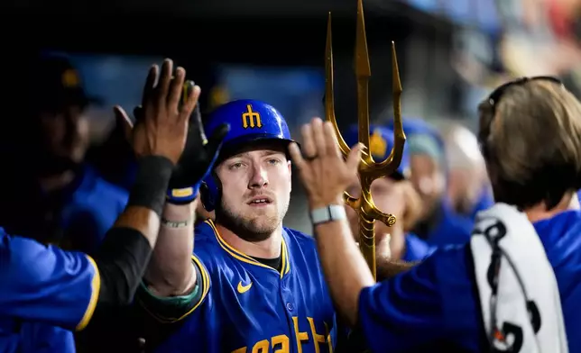 Seattle Mariners' Luke Raley holds a trident to celebrate hitting a solo home run against the San Francisco Giants during the fifth inning of a baseball game, Friday, Aug. 23, 2024, in Seattle. (AP Photo/Lindsey Wasson)