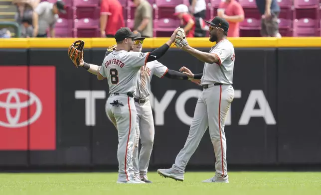 San Francisco Giants' Michael Conforto (8) celebrates with teammates Mike Yastrzemski, center, and Jerar Encarnacion, right, following their victory over the Cincinnati Reds in a baseball game, Sunday, Aug. 4, 2024, in Cincinnati. (AP Photo/Jeff Dean)