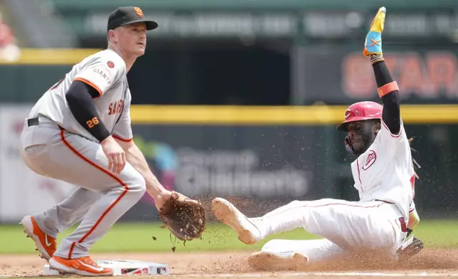 Cincinnati Reds' Elly De La Cruz, right, steals third base against San Francisco Giants third baseman Matt Chapman, left, during the sixth inning of a baseball game, Sunday, Aug. 4, 2024, in Cincinnati. (AP Photo/Jeff Dean)