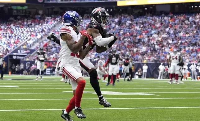 Houston Texans cornerback Derek Stingley Jr., right, intercepts a pass intended for New York Giants wide receiver Jalin Hyatt (13) that was thrown by quarterback Daniel Jones (8) in the first half of a preseason NFL football game, Saturday, Aug. 17, 2024, in Houston. (AP Photo/Eric Gay)