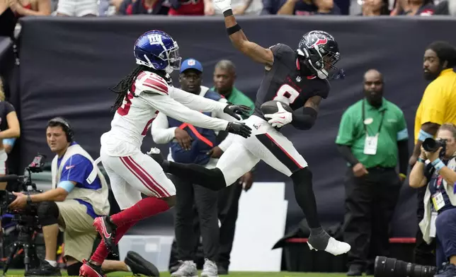 Houston Texans wide receiver John Metchie III (8) catches a pass in front of New York Giants cornerback Tre Herndon (23) in the first half of a preseason NFL football game, Saturday, Aug. 17, 2024, in Houston. (AP Photo/Eric Gay)