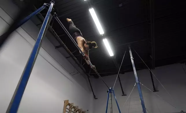 Angela Fuller, 44, works out on the high bar as she trains at 5280 Gymnastics, Wednesday, July 24, 2024, in Littleton, Colo. (AP Photo/Brittany Peterson)