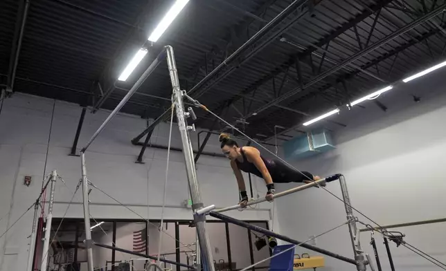 Angela Fuller, 44, works out on the uneven parallel bars as she trains at 5280 Gymnastics, Wednesday, July 24, 2024, in Littleton, Colo. (AP Photo/Brittany Peterson)