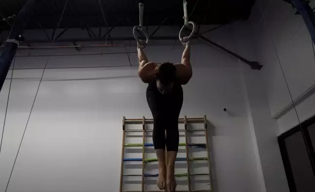 Angela Fuller, 44, works out on the rings as she trains at 5280 Gymnastics, Wednesday, July 24, 2024, in Littleton, Colo. (AP Photo/Brittany Peterson)