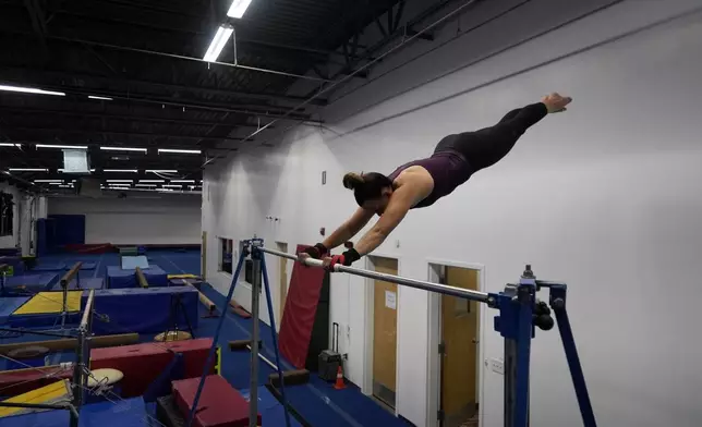 Angela Fuller, 44, works out on the high bar as she trains at 5280 Gymnastics, Wednesday, July 24, 2024, in Littleton, Colo. (AP Photo/Brittany Peterson)