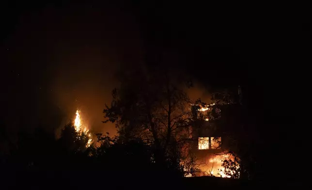 A house burns in Varnava village during a wildfire, north of Athens, Greece, Sunday, Aug. 11, 2024. Many regions of the country are on high alert due to high temperatures and winds. (AP Photo/Michael Varaklas)