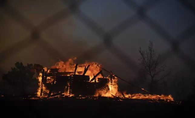 A house is on fire in Varnava village during a wildfire, north of Athens, Greece, Sunday, Aug. 11, 2024, with many regions of the country on high alert due to high temperatures and wind speeds. (AP Photo/Michael Varaklas)