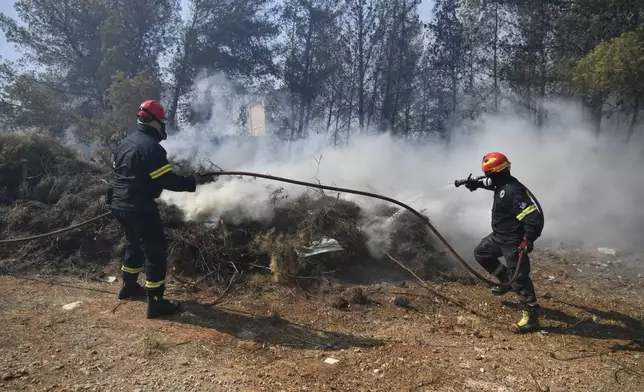 Firefighters operate in Dioni, northeast of Athens, Greece, Monday, Aug. 12, 2024. Hundreds of firefighters backed by dozens of water-dropping planes and helicopters were battling the flames from first light Monday, with a major forest fire that began the previous day raging out of control on the fringes of Athens, fanned by strong winds. (AP Photo/Michael Varaklas)