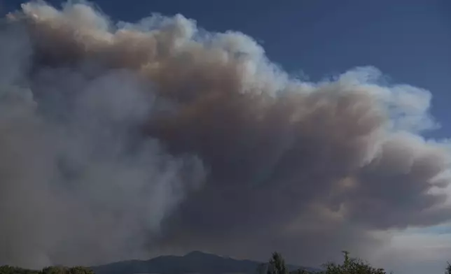 Smoke rises from a wildfire that broke out in Varnava village, north of Athens, Greece, Sunday, Aug. 11, 2024, with many regions of the country on high alert due to high temperatures and wind speeds. (AP Photo/Michael Varaklas)