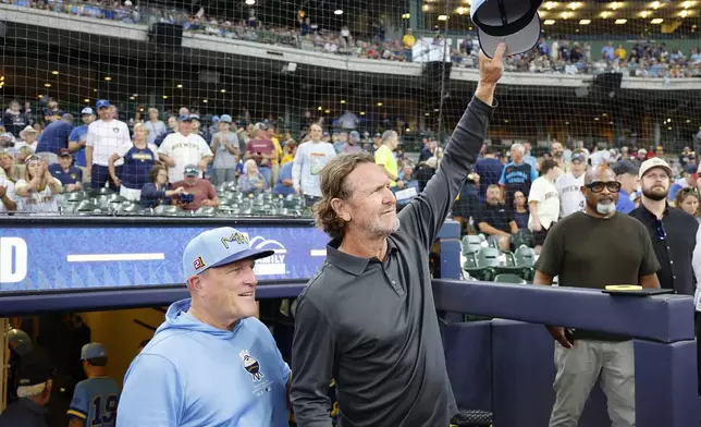 Former Milwaukee Brewers player and Hall of Fame member Robin Yount, front right waves to fans next to Brewers manager Pat Murphy, left, before a baseball game against the Cleveland Guardians, Sunday, Aug. 18, 2024, in Milwaukee. (AP Photo/Jeffrey Phelps)