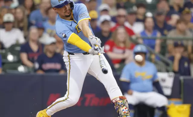 Milwaukee Brewers' Willy Adames hits a run-scoring single during the first inning of a baseball game against the Cleveland Guardians Sunday, Aug. 18, 2024, in Milwaukee. (AP Photo/Jeffrey Phelps)