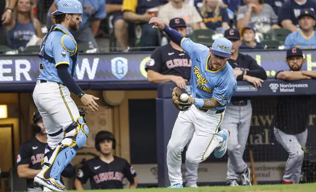 Milwaukee Brewers' Joey Ortiz, front right, catches a foul ball hit by Cleveland Guardians' Josh Naylor during the third inning of a baseball game Sunday, Aug. 18, 2024, in Milwaukee. (AP Photo/Jeffrey Phelps)