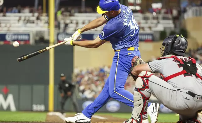 Minnesota Twins' Matt Wallner, left, hits a three-run home run against the Cleveland Guardians during the fifth inning of the second game of a baseball doubleheader, Friday, Aug. 9, 2024, in Minneapolis. (AP Photo/Matt Krohn)