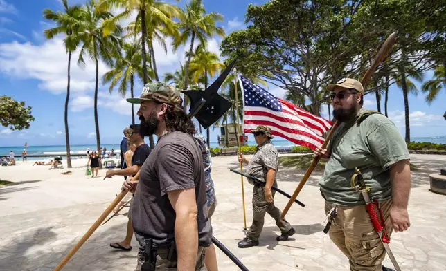 Members of Hawaii Firearms Coalition walk around Waikiki with their non-firearm weapons on Saturday, June 22, 2024, in Honolulu, Hawaii. (AP Photo/Mengshin Lin)