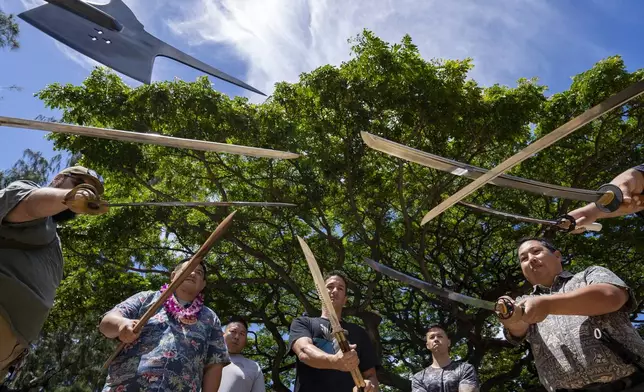 Members of Hawaii Firearms Coalition showcase their halberd, swords and balisong at Kapiolani Park on Saturday, June 22, 2024, in Honolulu, Hawaii. (AP Photo/Mengshin Lin)