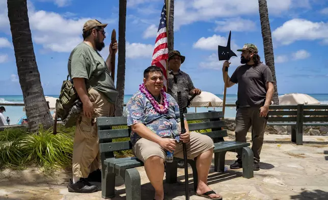 Members of Hawaii Firearms Coalition gather in Waikiki with their non-firearm weapons on Saturday, June 22, 2024, in Honolulu, Hawaii. (AP Photo/Mengshin Lin)